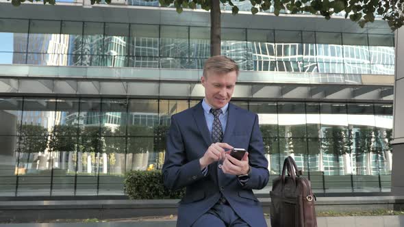 Man Excited for Success While Using Smartphone