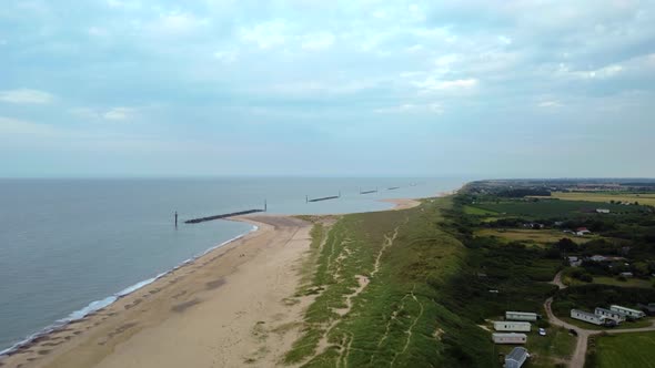Aerial over beach with breakwater sea defences in Norfolk, England