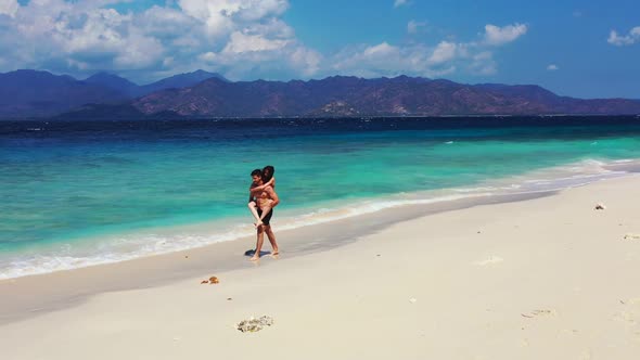 Guy and girl relax on relaxing bay beach break by blue lagoon and white sandy background of Gili Air