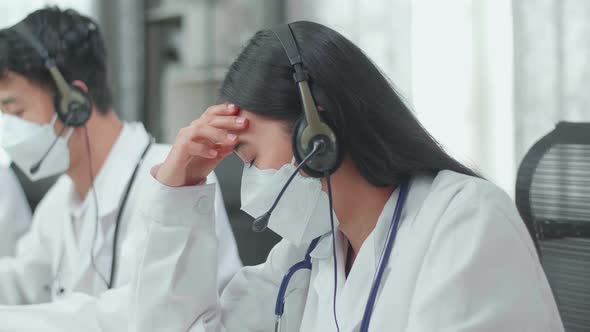 Close Up Of An Asian Woman Doctor Wearing Masks Working As Call Centre Agent Headache