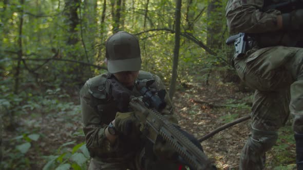 Closeup of Military Woman with Fully Equipped Squad Checking Firearms