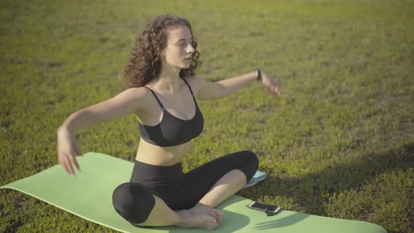 Relaxed Curly-haired Woman Putting Hands Together and Breathing Out. Portrait of Confident Caucasian