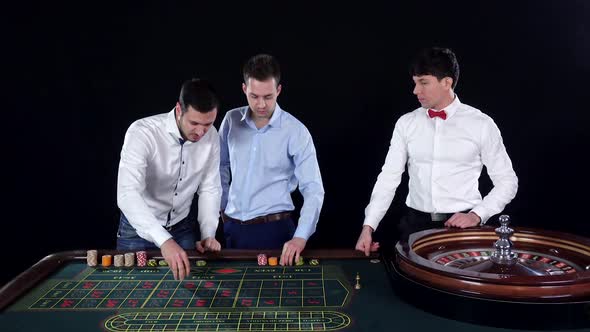 Three Guys Playing Roulette in the Casino. Black