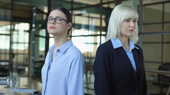 Two Business Women Standing Back to Back Looking Angrily, Career Competition