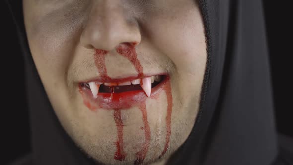Man Vampire Halloween Makeup and Costume. Guy with Blood on His Face