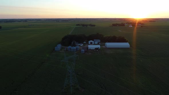 Flying over a farm at sunset in 4K