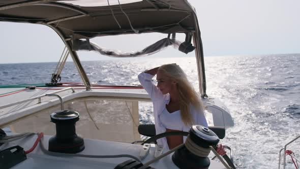 Woman Relaxing on a Cruise Catamaran Sail Boat Wearing White Summer Dress