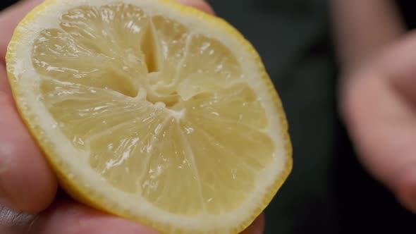 Professional chef squeezes lemon. Close up slow motion.
