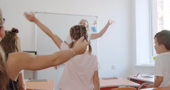 Positive Young Teacher Does Developing Exercises for Fingers in Light Living Room