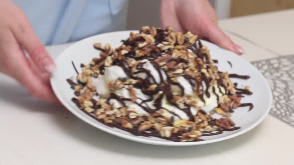 A Woman Demonstrates A Cake Made From Meringue, Cream And Chocolate. Close Up.