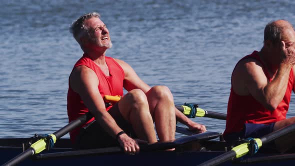 Two senior caucasian men in rowing boat resting
