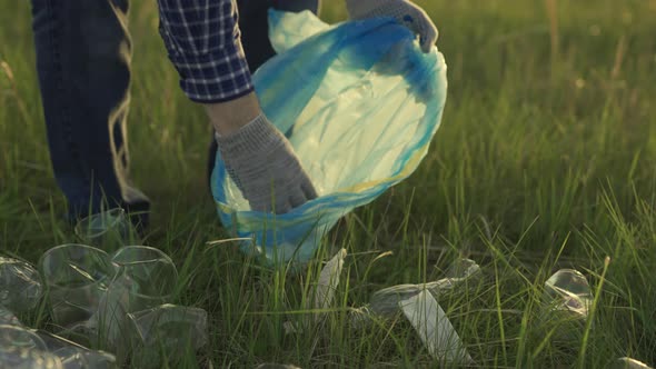 Volunteer a Man is Engaged in Cleaning Plastic Garbage in Park on Grass