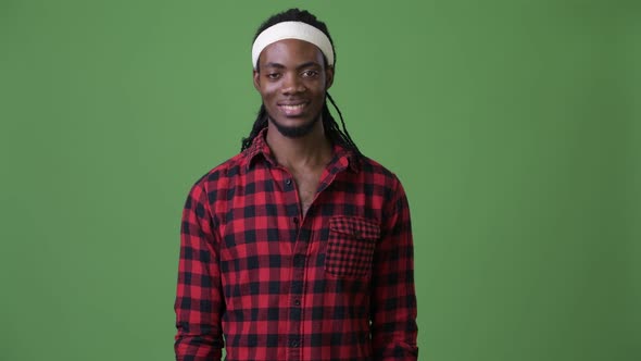 Young Handsome African Man with Dreadlocks Against Green Background