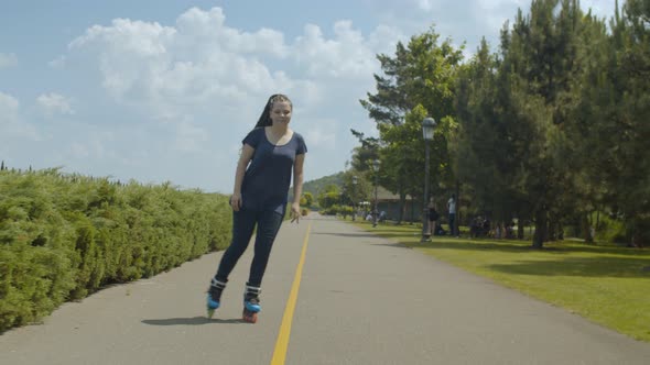 Young Woman Roller Enjoying Freeride in Green Park