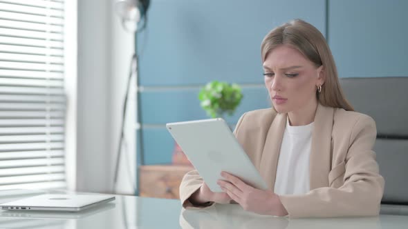 Businesswoman Reacting to Loss on Tablet in Office