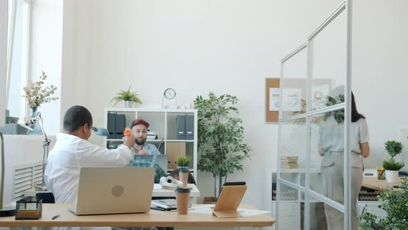 Diverse Group of Employees Enjoying Crazy Fun Fighting with Toy Guns and Running