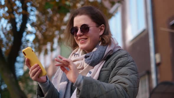 Woman Have a Talk By Smartphone Sitting on the Bench in the Street of Old Town  60p