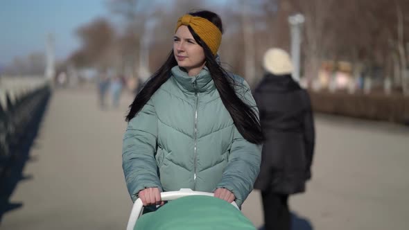 Woman Walking Through the Park with a Pram