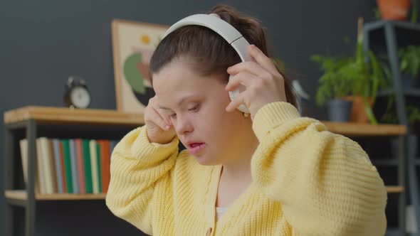 Girl with Down Syndrome in Headphones Playing Synthesizer