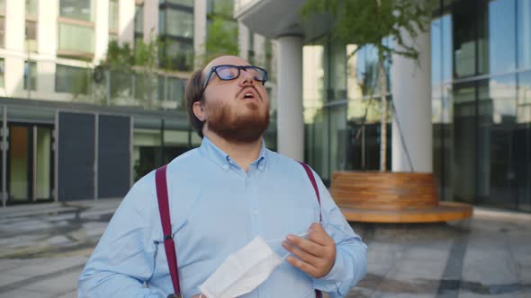 Overweight Office Worker Walking Down Street Putting Off Safety Mask