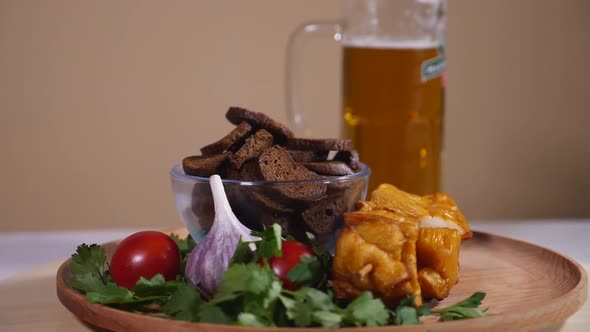 Tasty bread crackers, glass of beer, fish barbecue and vegetables