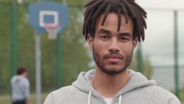 Portrait of Man with Dreadlocks on Outdoor Basketball Court