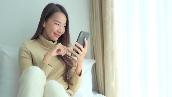 Young asian woman use smart phone in room