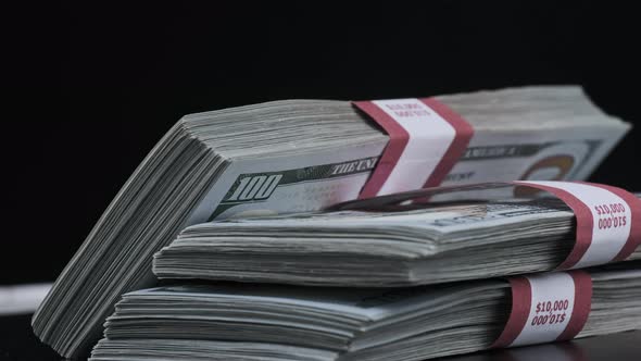 Bundles of Dollars Rotate on Black Background