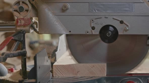 Man Cutting Plank with Bandsaw