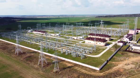 High voltage power plant with tall pylons and voltage distribution cables.