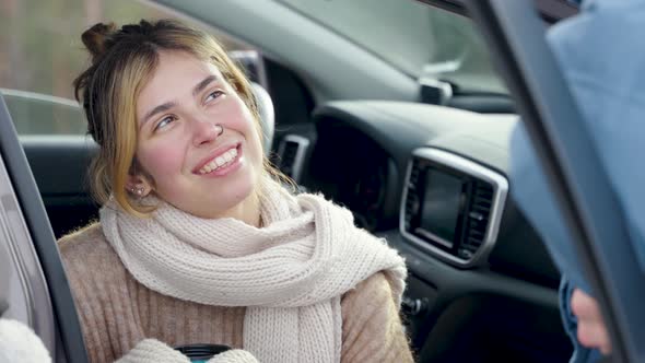 Female sitting and holding cup of hot beverage at cold winter day with snow