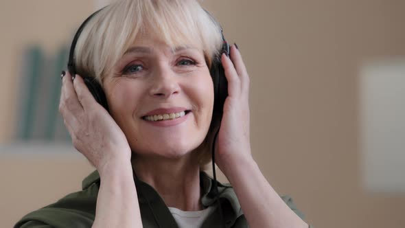 Beautiful Old Caucasian Woman in Headphones Happy Carefree Grandmother Relaxes to Songs Enjoys
