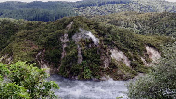 Wide shot of Frying Pan Lake emitting steam from fumaroles. Waimangu Volcanic Valley, Rotorua, New Z