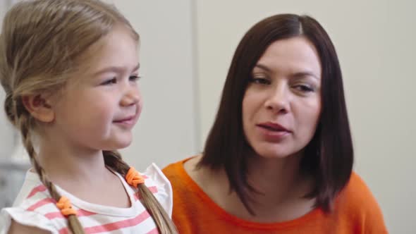 Little Girl and Mother Telling Story