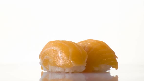 Two Spinning Salmon Sushi Isolated on the White Background