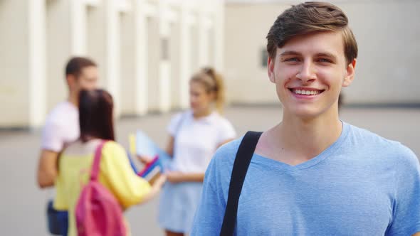 Smiling Student Looking at Camera Against College Building