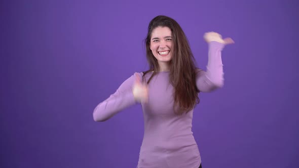 The Portrait of a Girl Delighted with the Idea That Shows with Both Hands the Like Sign and Moves