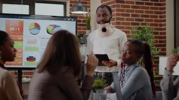 African American Man with Cervical Neck Collar Doing Wrok Presentation