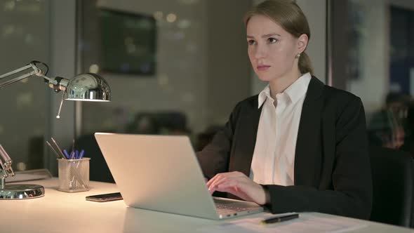 Ambitious Businesswoman Thinking and Working on Laptop at Night