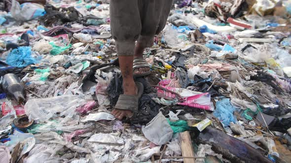 Poverty Boy's Legs Walking On Garbage Dump