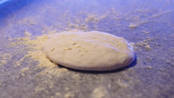 Pizza Dough Falls on the Table with Flour