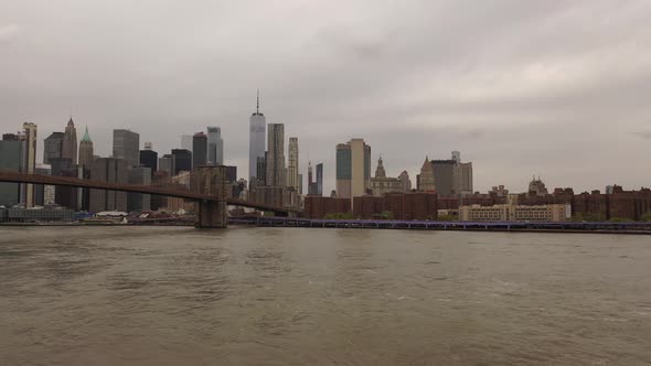 An aerial view over the East River on a cloudy day. The drone camera pan left on the north side of t