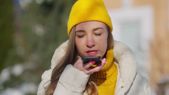 Closeup Portrait of Confident Female Millennial Recording Voice Mail on Smartphone Outdoors