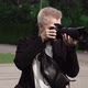 Male Photographer Takes Photos on a Professional Camera Outdoors in Park - VideoHive Item for Sale