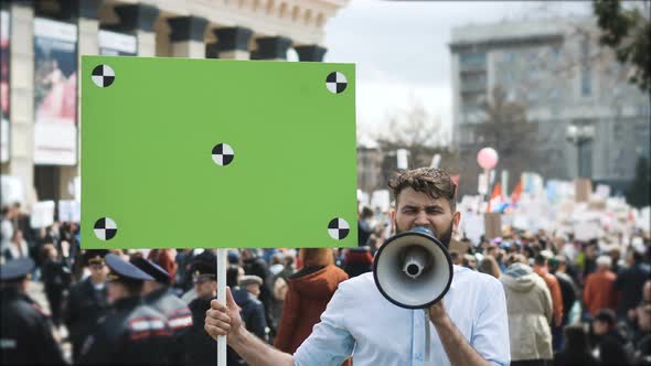 European People at Demonstration. Man with a Banner Screaming Into a Mouthpiece