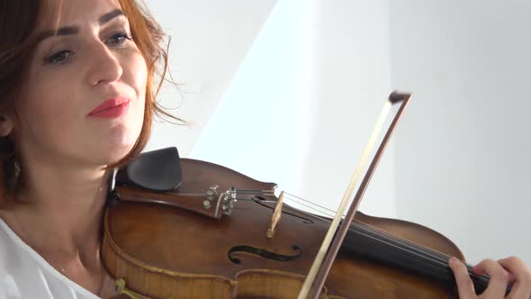 Girl Fingering the Strings Playing the Violin. Close Up. White Background