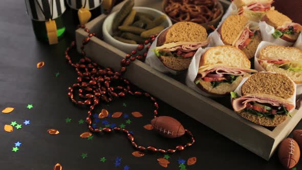 Game day football party table with  sub sandwich and snacks.