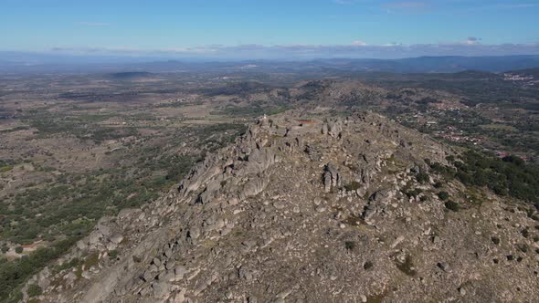 Aerial circling around ancient Monsanto castle and surrounding landscape in Portugal