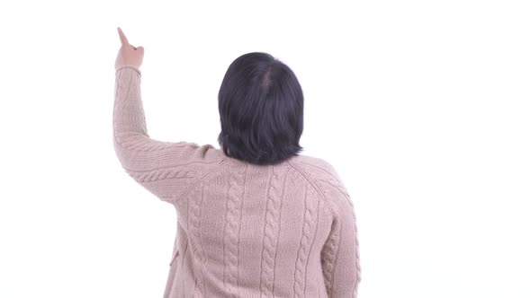Rear View of Overweight Asian Woman Pointing Finger and Ready for Winter