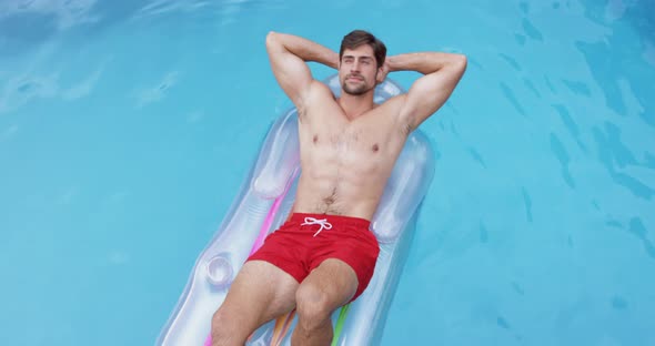 Man relaxing with hands behind head on inflatable tube in swimming pool 4k